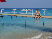 2020.08.20 On a Turkish pier of the Mediterranean Sea: sitting, legs dangling.