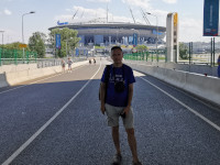 2021.07.11 On the pedestrian Yacht Bridge with the “GazProm Arena” stadium and the Carillon in the background.