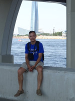 2021-07-11. Сидя на бордюре поребрике набережной Невской губы на фоне Лахта-центра и «футбольной» студии «Матч-ТВ».