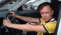 2022-06-11. Behind the wheel of my own car but still on a parking; a horizontal portrait so you can see that I am really behind the wheel, holding it. 😊