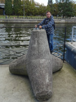 2022-10-09. I am modestly demonstrating how strong I am by lifting the “hedgehog” breakwater on the embankment of the New Pregola, near the Philosophical Bridge, in Kaliningrad (Königsberg), Russia.
