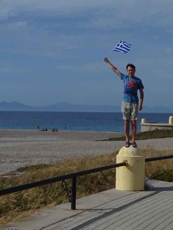 2019.06.02 «Статуя» с греческим флагом у северной оконечности Родоса со слиянием Эгейского и Средиземного морей.