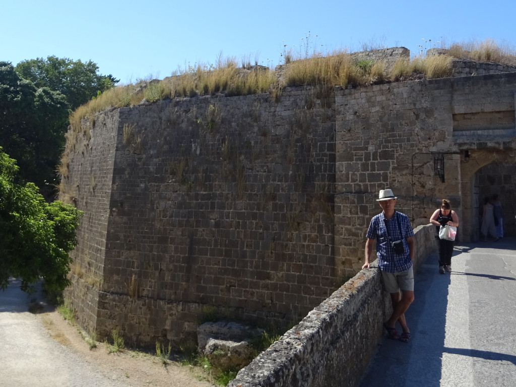 2019.06.06 On the bridge to an entrance to the Old Town of Rhodes, with its severe wall in the background.