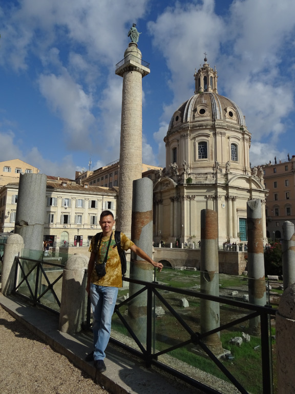 2019.10.03 Against the background of Trajan's Forum (below), his Column (farther in the center), Palazzo Valentini (behind it at the left) and the Church of the Holy Name of Mary (behind it at the right).