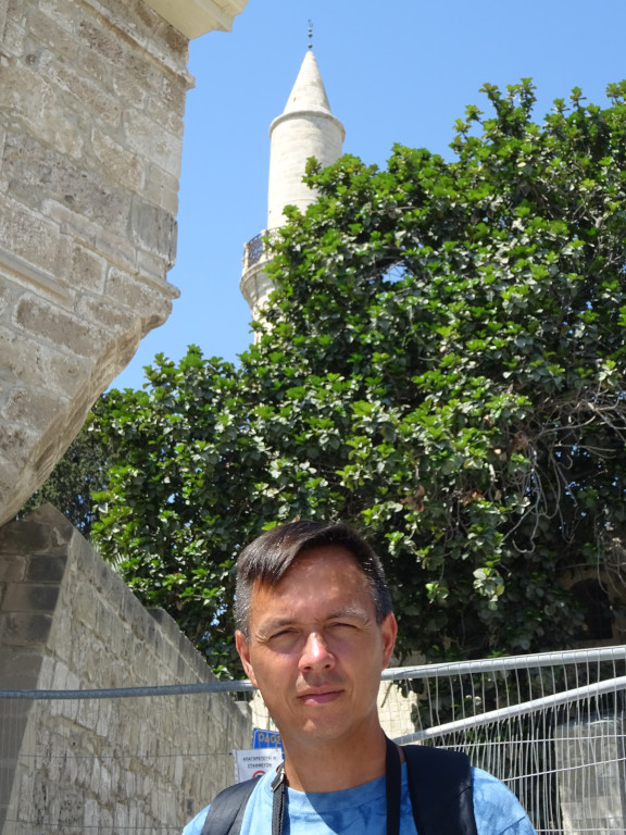 2021.08.02 With the wall of the Larnaca Medieval Fort (Κάστρο Λάρνακας) and the minaret of the Grand Mosque (المسجد الكبير) of Larnaca, also known as Djami Kebir Mosque.