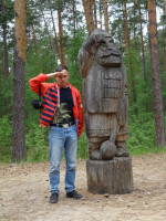 2022.06.19 With a wooden sculpture of some fairy bogatyr in the “Fairy Tale” Park in Gus-Khrustalny (the Vladimir region, Russia).