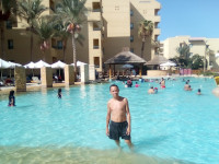 2022.08.19 The large swimming pool of the “Zakhabia” hotel in Hurghada (Egypt), in addition to the water slides (a piece of one is visible at the right edge of the photograph), pleased with the imitation of a gentle sandy bottom and an abundance of sociable locals.