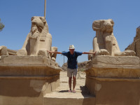 2022.08.21 The same mutton-like sphinxes, only now at the exit from the Karnak Temple (Ipt-swt) complex, and I am stretching between them for good luck.