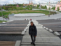 На лестнице (частично крытого) амфитеатра на холме парка Зарядье с видом на московский Кремль.