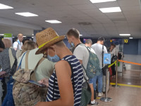 Старший сын в не помню откуда взявшейся шляпе стои́т в очереди на регистрацию в терминале внутренних рейсов краснодарского аэропорта Пашковский, в котором даже потолки низкие.