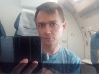 Эксперименты неопытного самопортретиста в экране самолётного дисплея: вертикальная ориентация смартфона, взгляд попал в объектив.