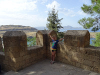 На этой фотографии с теми же стенами акрополя Линдоса (ακρόπολη της Λίνδου) лучше видно удивительно приятное сочетание: лето, горы, море, зелень, ребёнок! 😍