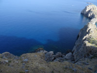 Вид с вершины акрополя Линдоса (ακρόπολη της Λίνδου) по скалам вниз, в синеву глубины Средиземного моря (Μεσόγειος Θάλασσα).