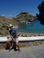 Один на фоне сердцеобразной бухты святого Павла (κόλπος του Αγίου Παύλου, вид с дороги к ней) и акрополя Линдоса (ακρόπολη της Λίνδου).