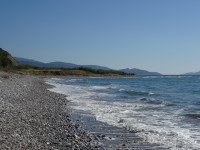 Дикий крупногалечный пляж Эгейского моря (Αιγαίο πέλαγος), омывающего Родос (Ρόδος), взгляд в сторону юга.