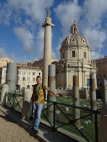Я на фоне форума Траяна (Forum Traiani; внизу), его же колонны (Columna Traiana, 113 год; вдалеке по центру), дворца Валентина (Palazzo Valentini, 1585; за колонной слева) и Церкви святого имени Марии (Chiesa Santissimo Nome di Maria, 1751; за колонной справа).