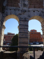 Вид изнутри арок Колизея (Colosseus) на одноимённую площадь (Piazza del Colosseo), которая больше улица, дом 4, и улицу Клаудии (Via Claudia), дом 8.