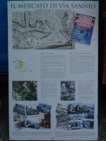 История легендарного рынка на улице Саннио (Mercato di Via Sannio) на плакате рядом с ним.