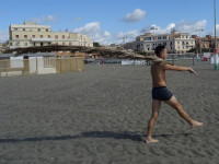Пальмовый страж пляжа в городке Лидо ди Остия (Lido di Ostia) со столбом, окрашенным в цвета флага страны.