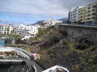 Пуэрто-де-Сантьяго (Puerto de Santiago), проспект 5° столетия (Avenida 5° Centenario). Вид на пляж Чика (Play Chica, слева внизу), сам проспект (справа, уходящий вверх) и скалы Гигантес (los Gigantes, прямо вдалеке).