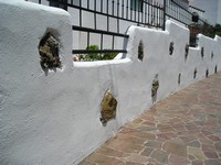 Пуэрто-де-Сантьяго (Puerto de Santiago), проспект 5° столетия (Avenida 5° Centenario). Натуральные мотивы во всём, в данном случае – в естественных, необработанных камнях в отштукатуренном заборе.