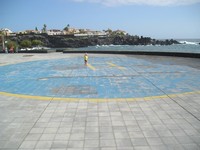 Пуэрто-де-Сантьяго (Puerto de Santiago), вертолётная площадка (Helipuerto). Рат в подходящей жёлтой футболке почти по центру площадки рядом с буквой “H”.