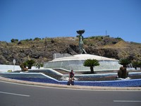 Сантьяго-дель-Тейде (Santiago del Teide), круг на стыке улицы Петуния (Calle Petunia), проспекта 5° столетия (Avenida 5° Centenario) и шоссе TF-454, ведущего к Тейде. Монумент «Рыбачка» (Pescadora) с фонтаном и мной.