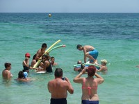 Пляж гостиницы Selima Club. Я встаю на доску для сёрфинга (первый раз в жизни), чтобы защитить честь пляжной команды в битве на поролоновых палках. 😊 Мой противник – Алексей, папа малыша Феди. 😊