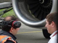 Оперативка авиатехника и какого-то аэропортового служащего у двигателя нашего самолёта.