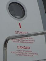 Надпись на двери нашего/любого самолёта: «Опасно. Не открывать дверь при мигающем красном предупредительном сигнале (кабина под давлением)» (по-английски: “Danger. Do not open door if red warning light is flashing (cabin pressurized!)”).