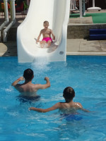 Младший к тому моменту уже́ умел плавать, но почему-то я всё равно ловлю его после спуска с водной горки. 🤔