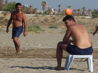 Непринуждённо удерживает волейбольный мяч на голове. 😊 (На самом деле по рукам у правого края кадра видно, что мяч летит к ним и вот-вот будет принят, а сидящий на стуле просто находится ближе к фотографу.)